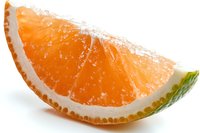Fresh juicy orange segment with visible pulp and white pith on white background, macro shot showing detailed texture and natural citrus fruit structure.