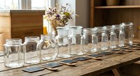 Empty glass mason jars arranged in row on wooden table for food storage, canning, preserving, kitchen organization and pantry preparation in rustic home interior.