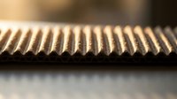 Close-up macro view of metal gear rack with precise teeth pattern showing industrial engineering detail for mechanical design applications.
