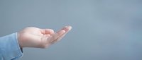 Open palm of a Caucasian person wearing a light blue shirt against a soft gray background, conveying concepts of giving, offering, support, and care for presentations and marketing materials.
