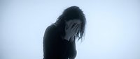 Young woman covering face with hands expressing grief, depression or emotional pain against minimalist background for mental health concepts.