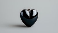 Black glossy heart shape with dramatic crack or split running through middle on neutral gray background, symbolizing broken relationship and emotional pain.