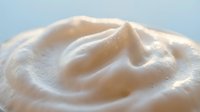 Smooth creamy white cosmetic texture with swirled pattern for skincare and beauty product applications in spa and wellness industry.