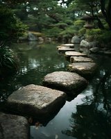 Tranquil Japanese garden with stone path crossing serene pond, surrounded by lush greenery and traditional stone lantern.
