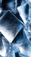 Macro view of transparent ice crystals with geometric shapes and natural patterns in cool blue tones, showing frozen water structure and light reflections.