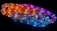 Colorful LED rope light glowing with vibrant rainbow colors against dark background, featuring orange, purple and blue illuminated sections in curved pattern.