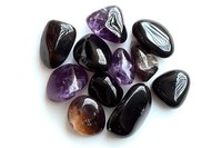 Collection of polished purple and black gemstones including amethyst and obsidian crystals isolated on white background for jewelry making and healing.