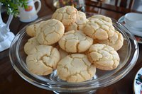 Homemade crackle sugar cookies with distinctive crinkled surface served on glass cake stand, fresh baked with golden brown edges and soft centers.