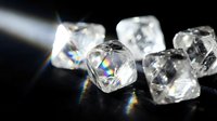 Sparkling clear diamonds scattered on dark surface with rainbow light reflections creating luxury jewelry and gemstone display for precious stone collection.