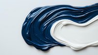 Flowing navy blue and white paint swirls create dynamic abstract waves against light background, showcasing fluid movement and artistic texture for creative designs.