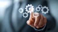 Businessman touching virtual gear icons, representing business process automation, technology integration, and strategic management solutions.