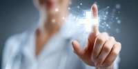 Medical professional touching glowing cross symbol on virtual screen, representing healthcare technology and digital medical innovations in modern medicine.