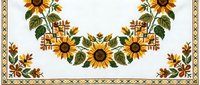 Cross stitch embroidery pattern with sunflowers and autumn leaves forming a floral garland border on white fabric for needlework.