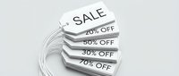 Stack of white sale price tags showing discount percentages 20, 30, 50, 70 percent off, arranged in a fan on light background.