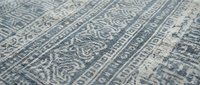 Close-up of intricate geometric textile pattern with traditional ornamental design in blue and beige colors for interior decoration and fabric projects.