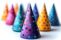 Colorful polka dot party hats arranged in rows with selective focus on purple cone in foreground. Festive celebration accessories against white background.