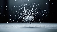 Dramatic explosion of white salt crystals floating in mid-air against dark background, captured in high-speed photography. Dynamic food ingredient motion.