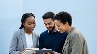 Young diverse professionals reviewing documents together, suitable for business, teamwork, education and corporate training materials.