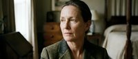 Middle-aged woman with dark hair, Caucasian ethnicity, wearing olive green cardigan in contemplative indoor setting. Suitable for drama, psychology, healthcare, and editorial use.