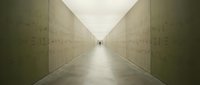 Long concrete corridor with minimalist design and distant figure, suitable for corporate, architectural, and conceptual projects.