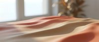 Soft flowing fabric in warm coral and peach tones with gentle shadows and natural window light creating elegant textile waves for interior design projects.