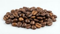 Roasted coffee beans pile isolated on white background for cafe menu design, brewing concepts and beverage industry marketing materials.