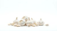 Isolated white garlic bulbs and cloves arranged on clean background, ready for culinary, food packaging, recipe, and cooking-related design projects.
