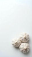Three whole garlic bulbs with papery white skin arranged on neutral background, isolated and ready for culinary, food styling, recipe, and cooking-related design projects.