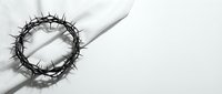 Crown of thorns resting on white fabric with dramatic shadow, symbolizing sacrifice, redemption, and religious faith for Easter and Christian spiritual concepts.