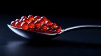 Fresh red caviar on silver spoon against dark background, luxury seafood delicacy with glossy texture and vibrant color for gourmet cuisine and fine dining.