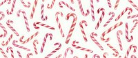 Festive candy canes scattered on white background creating cheerful holiday pattern for Christmas decorations and seasonal designs.