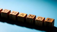 Wooden letter blocks spelling CHANGE on a blue background, symbolizing transformation, growth, and new beginnings in business and personal development.