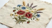 Vintage embroidered linen fabric with colorful wildflower bouquet featuring poppies, cornflowers, wheat and lavender on natural beige textile background.