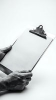 Hands holding blank clipboard with metal clip on white background, monochrome business document template for forms, surveys, contracts and office paperwork.
