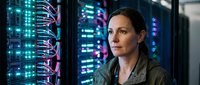 Female IT professional working in modern data center with glowing server racks and network cables. Technology specialist monitoring computer systems.