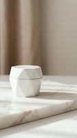 White ceramic cosmetic jar on marble surface with soft beige curtain background for skincare product mockup and beauty brand presentation.