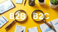 Professional business comparison showing B2B and B2C text under magnifying glasses on yellow desk with analytics charts, coffee cup, and plant for corporate strategy and market analysis.