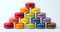Colorful French macarons stacked in a pyramid on white background, showcasing vibrant pastel shades for bakery, food blog, or menu use.