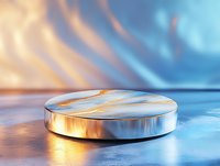 Metallic round podium with reflective surface on gradient background with warm and cool light effects, suitable for product display and showcase presentations.