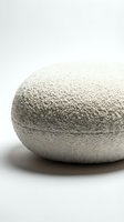 Round boucle pouf ottoman in cream white textured fabric on light background, cozy minimalist home decor furniture for living room.