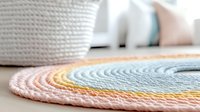 Pastel round braided rug with pink, yellow and mint colors on wooden floor near white woven basket, creating cozy nursery or living room decor atmosphere.