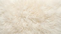 Soft cream colored fluffy fur texture background with long wavy fibers creating cozy warm surface for interior design and comfort concepts.