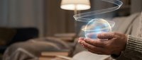 Hands holding glowing digital sphere with swirling light trails in cozy home interior. Futuristic technology concept for innovation and digital transformation.