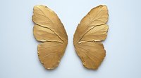 Golden butterfly wings with detailed leaf-like texture and veining pattern on white background, isolated design element for creative projects and decorative art.