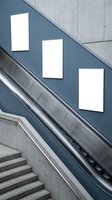 Modern staircase with escalator featuring three blank white frames on blue wall panel. Contemporary architecture interior design for advertising, branding, and commercial display purposes.