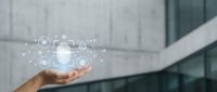 Businessperson holding glowing digital cloud network with connected icons, representing data storage, technology infrastructure, and cloud computing solutions for enterprise applications.