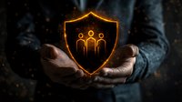 Male hands holding glowing orange shield with family protection symbol against dark background, representing insurance and security concept.