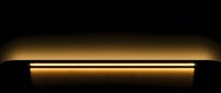 Glowing golden neon tube emitting warm light against dark background, suitable for modern interior design, signage, and contemporary decor projects.