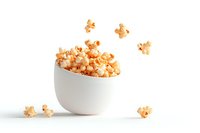 Fresh popcorn overflowing from modern white ceramic bowl with scattered kernels on white background, isolated food photography for snack and entertainment concepts.