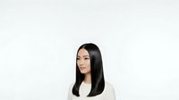 Young woman with long black hair and East Asian ethnicity wearing white blazer against neutral background, isolated for design use.